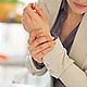 Weibliche Person hat Schmerzen am Handgelenk | Tiger Balm